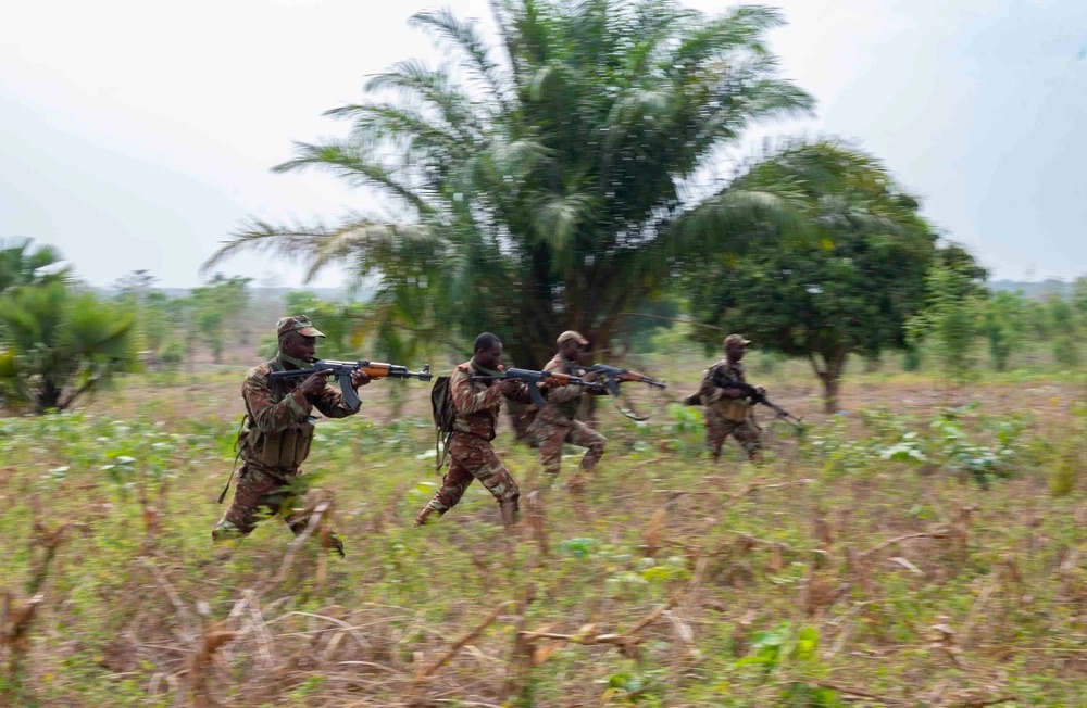 A squad of soldiers from the Benin 1st Commando Parachute Battalion advance on an enemy position during a Joint Combined Exchange Training scenario.